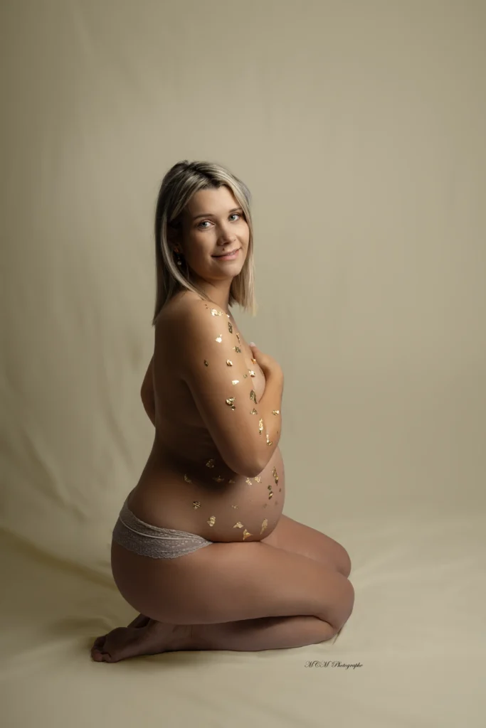 Photo de Caroline Lafargue, MCM Photographe, représentant une femme enceinte dans une robe noire entourée de ses deux filles portant un body noire sur fond blanc